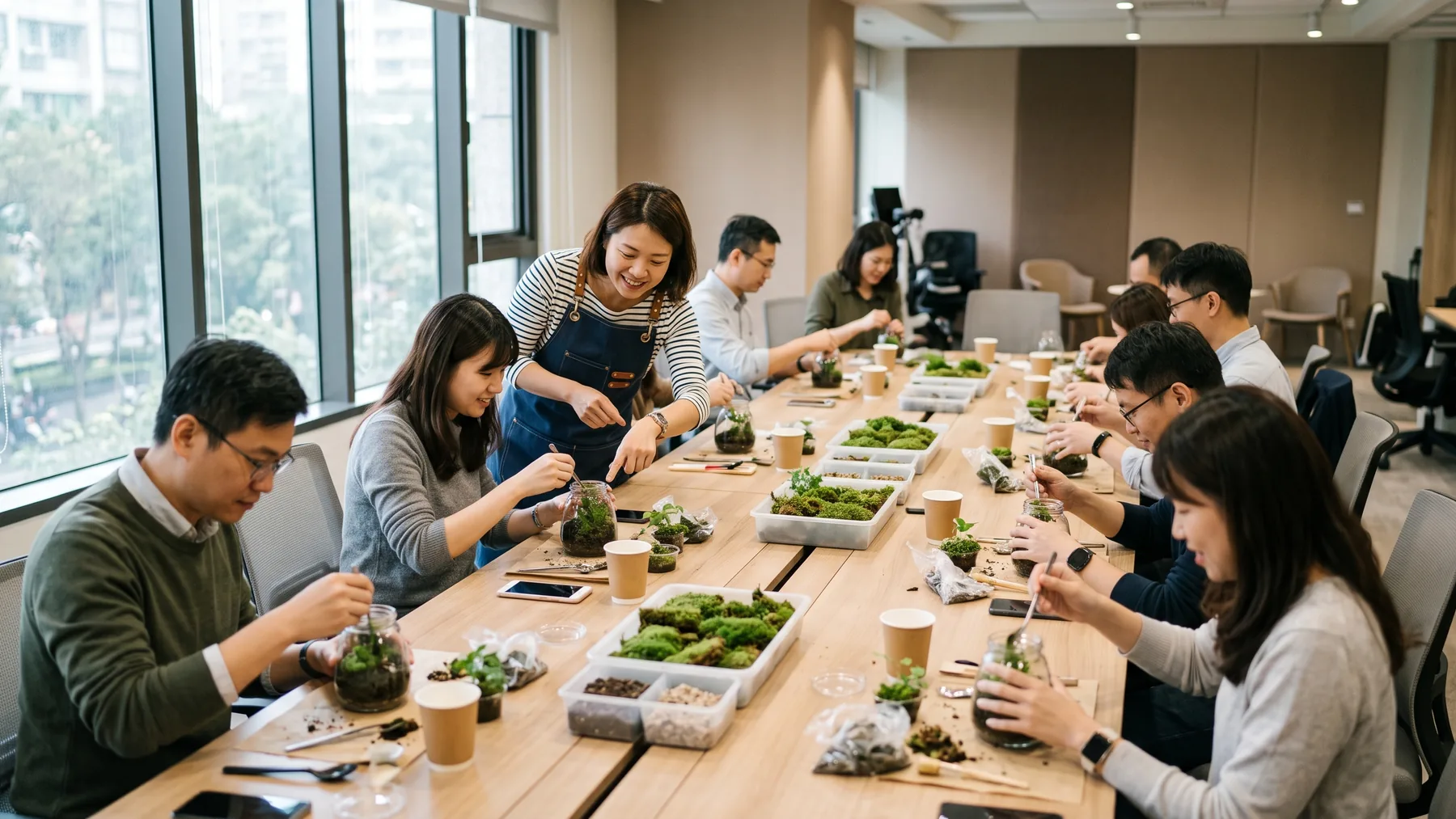 十多位同事圍著會議室長桌製作苔蘚微景觀，帶領師在旁指導